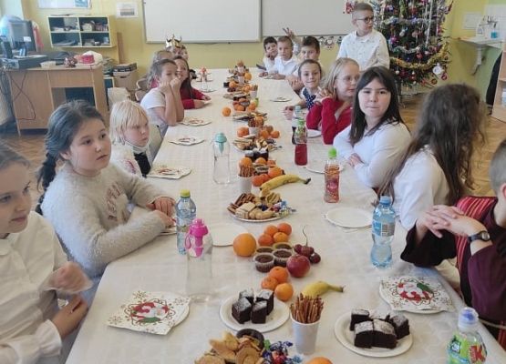 Uczniowie siedzą przy wigilijnym stole