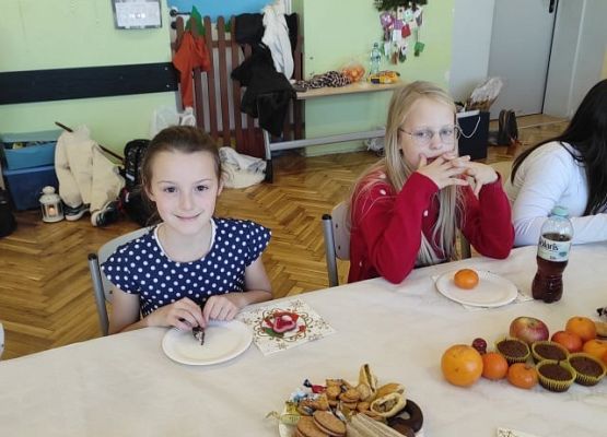 Uczniowie siedzą przy wigilijnym stole