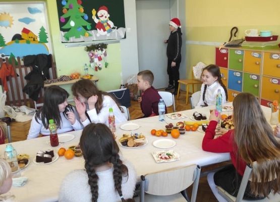 Uczniowie siedzą przy wigilijnym stole