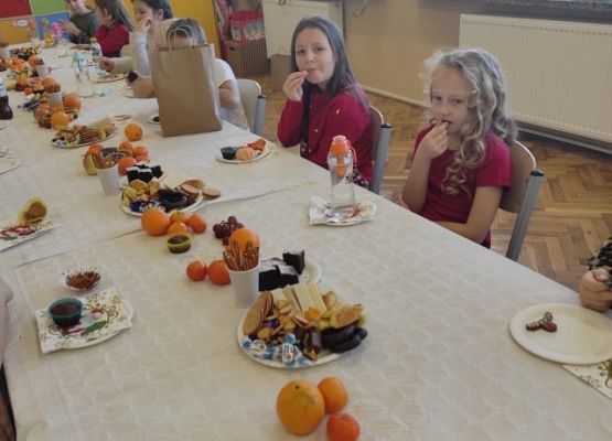 Uczniowie siedzą przy wigilijnym stole