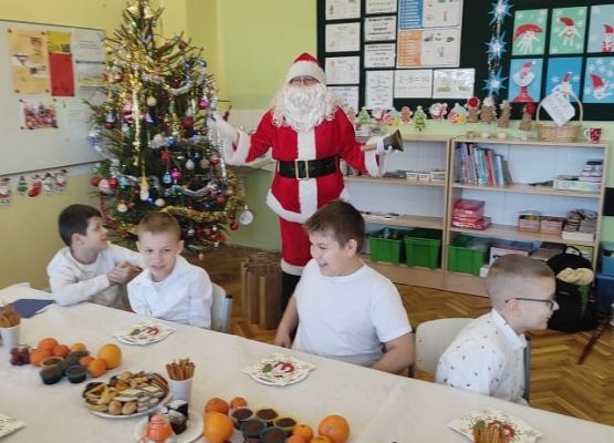 Uczniowie siedzą przy wigilijnym stole