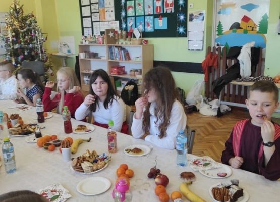 Uczniowie siedzą przy wigilijnym stole