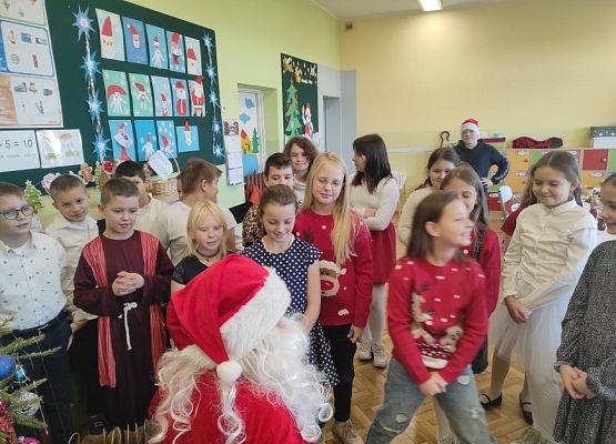 Uczniowie siedzą przy wigilijnym stole