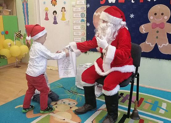 Chłopiec otrzymuje prezent od Mikołaja