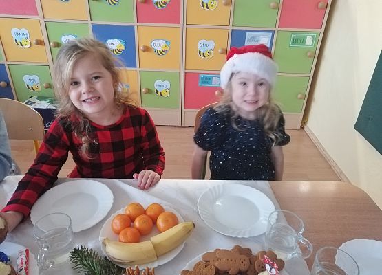 Dzieci siedzą przy wigilijnym stole