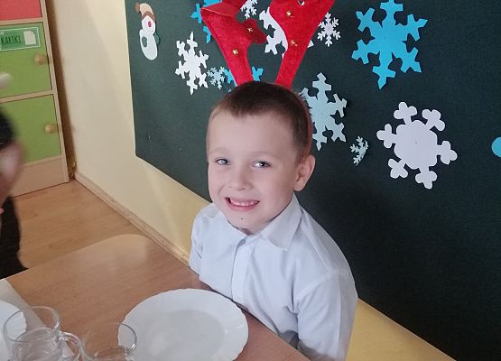 Chłopiec siedzi przy wigilijnym stole