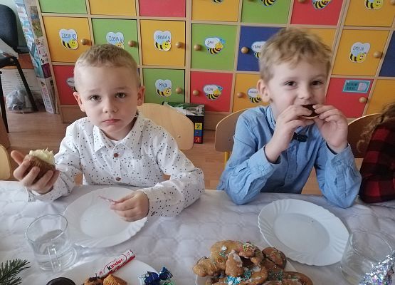 Dzieci siedzą przy wigilijnym stole