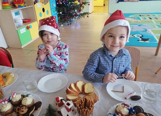 Dzieci siedzą przy wigilijnym stole