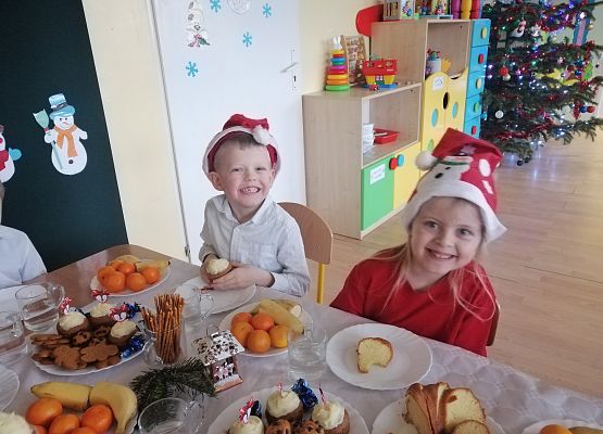 Dzieci siedzą przy wigilijnym stole