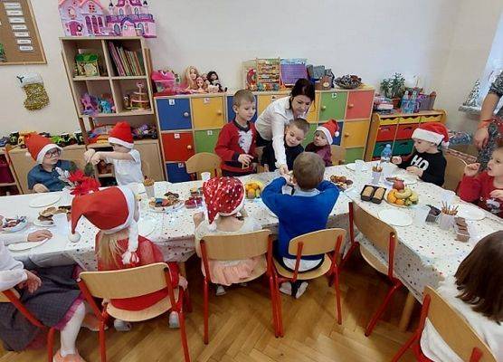 Dzieci siedzą przy wigilijnym stole