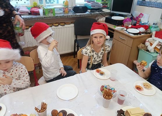 Dzieci siedzą przy wigilijnym stole