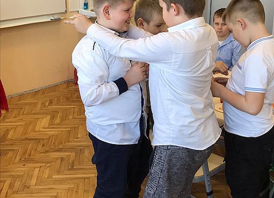 Chłopcy łamią się opłatkiem składając sobie życzenia