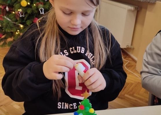 Uczennica ozdabia choinkę