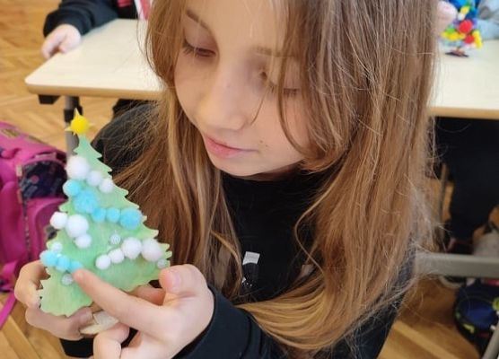 Uczennica ozdabia choinkę