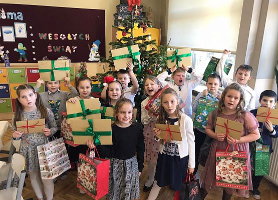 Uczniowie przy choince z upominkami dla rodziców.