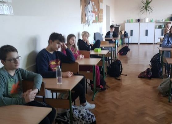 Uczniowie siedzą w ławkach