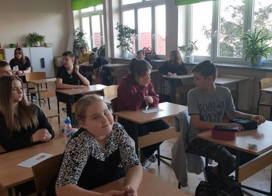 Uczniowie siedzą w ławkach