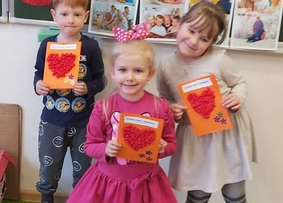 dzieci prezentują wykonane laurki dla babć i dziadków