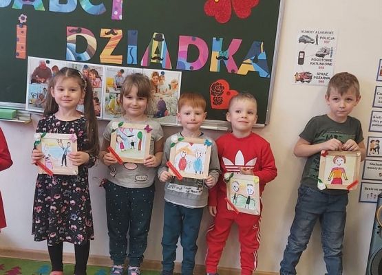 dzieci prezentują wykonane laurki dla babć i dziadków