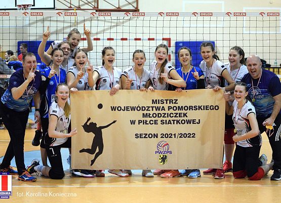 Grupa siatkarek trzyma afisz zawodów