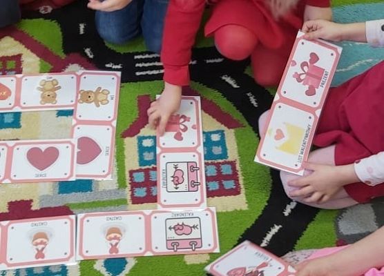 Dzieci układają domino na dywanie