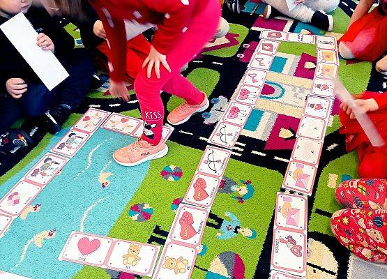Dzieci układają domino na dywanie