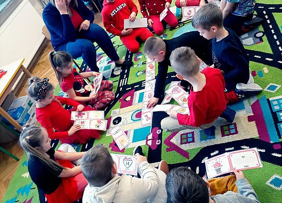 Dzieci układają domino na dywanie