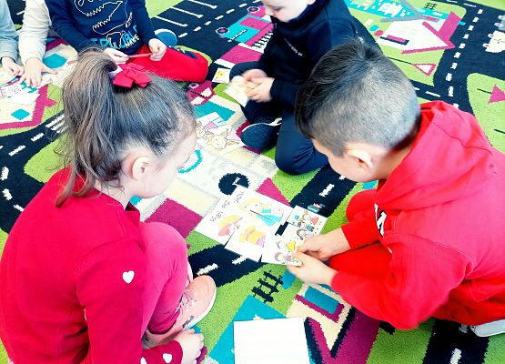 Dzieci układają domino na dywanie