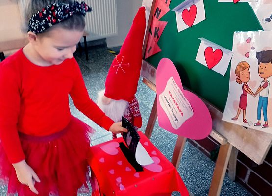 Dziewczynka wrzuca walentynkę do skrzynki