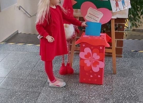 Dziewczynka wrzuca walentynkę do skrzynki
