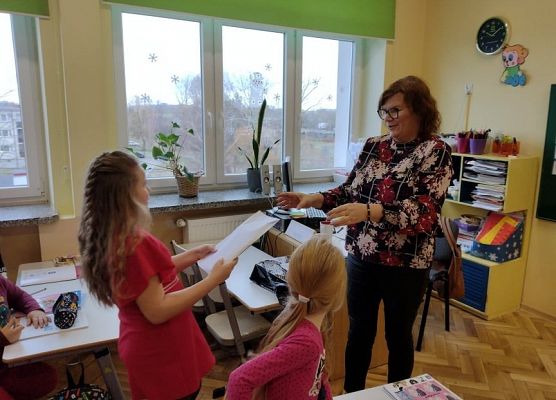 Uczennica wręcza nauczycielce kopertę z walentynkami