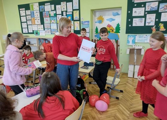 Uczennica wręcza nauczycielce kopertę z walentynkami