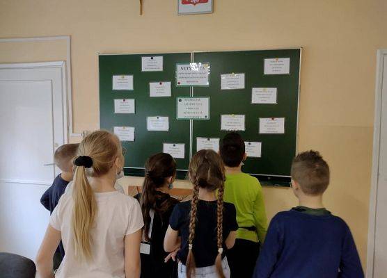 Uczniowie odczytują hasła bezpiecznego korzystania z internetu