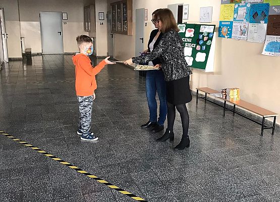 Pani wicedyrektor i pedagog wręczają uczniowi dyplom