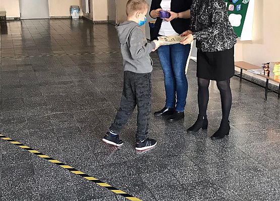 Pani wicedyrektor i pedagog wręczają uczniowi dyplom