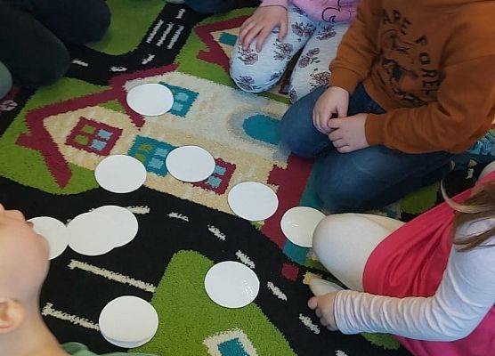 Dzieci siedzą na dywanie