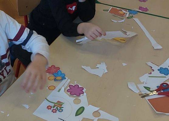 Chłopcy wycinają papierowe kwiaty