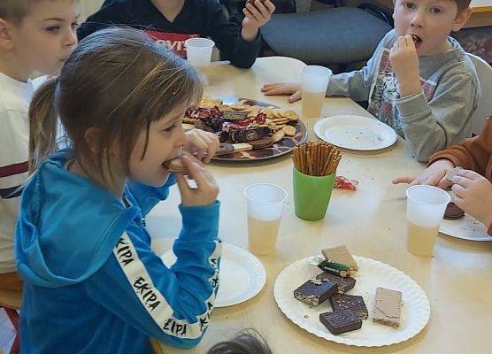 Słodki poczęstunek. dzieci siedzą przy stoliku