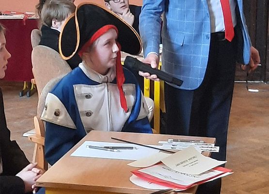 Uczennica w stroju Napoleona odpowiada na pytanie