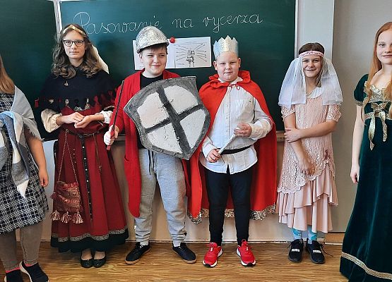 Uczniowie klasy V na lekcji historii odgrywają scenki z pasowania na rycerza
