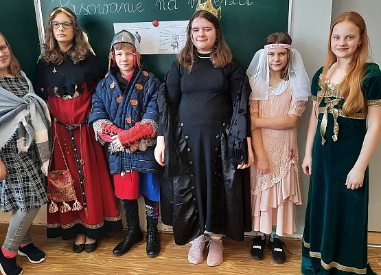 Uczniowie klasy V na lekcji historii odgrywają scenki z pasowania na rycerza