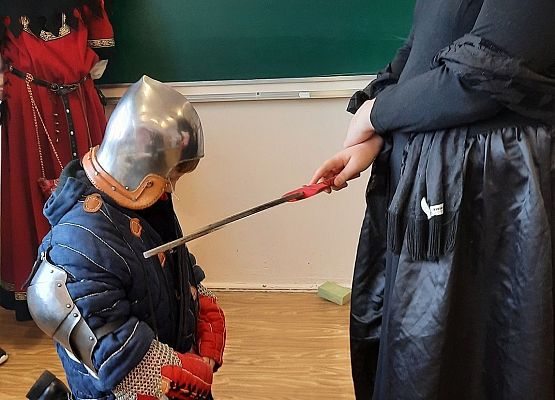 Uczniowie klasy V na lekcji historii odgrywają scenki z pasowania na rycerza