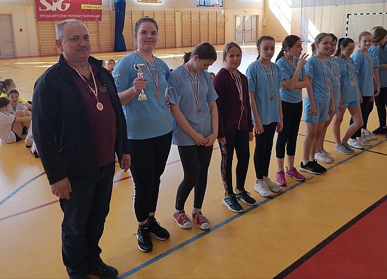 Zawodniczki stoją podczas wręczania nagród obok stoi trener