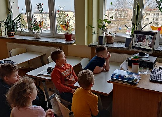 Uczniowie siedzą  i oglądają film