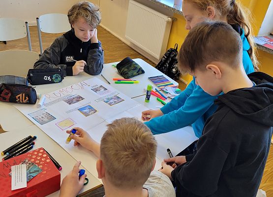 Uczniowie pracują w grupie - tworzą plakat