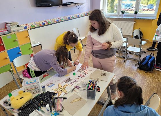 Uczniowie pracują w grupie - tworzą plakat