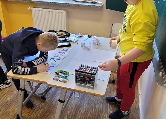 Uczniowie pracują w grupie - tworzą plakat