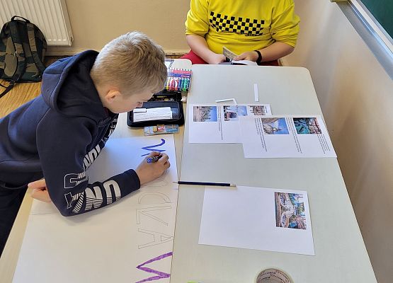 Uczniowie pracują w grupie - tworzą plakat