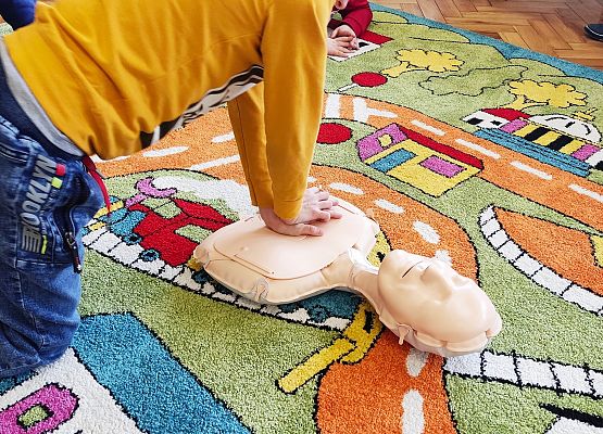 Chłopiec uczy się na fantomie reanimacji