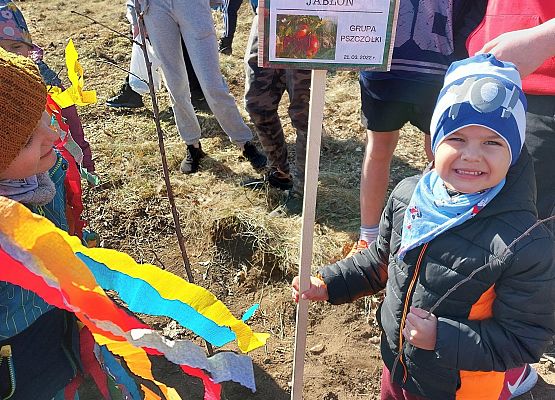 Chłopiec trzyma tabliczkę z napisem jabłoń